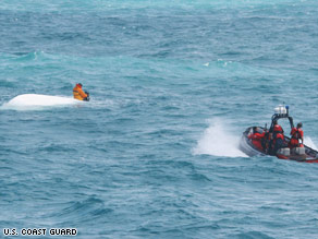 Photo Of Nick Schuyler Hanging On To Boat While Coast Guard Rescuses Him.  Photo: U.S. Coast Guard